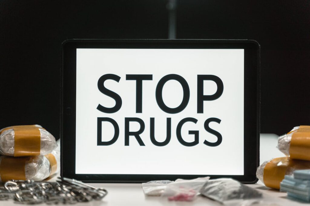 Tablet screen displaying anti-drug message surrounded by packaged substances, promoting awareness.